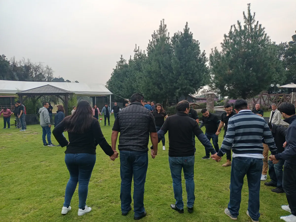 Dinámica al aire libre con participantes tomados de la mano